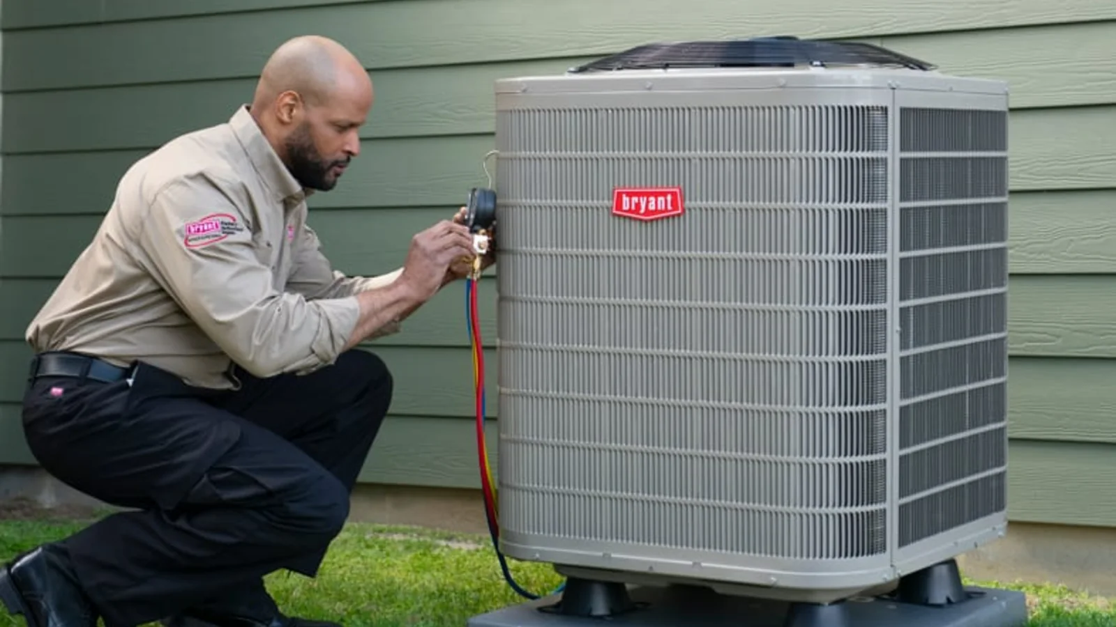 Bryant dealer servicing an outdoor air conditioner beside a home