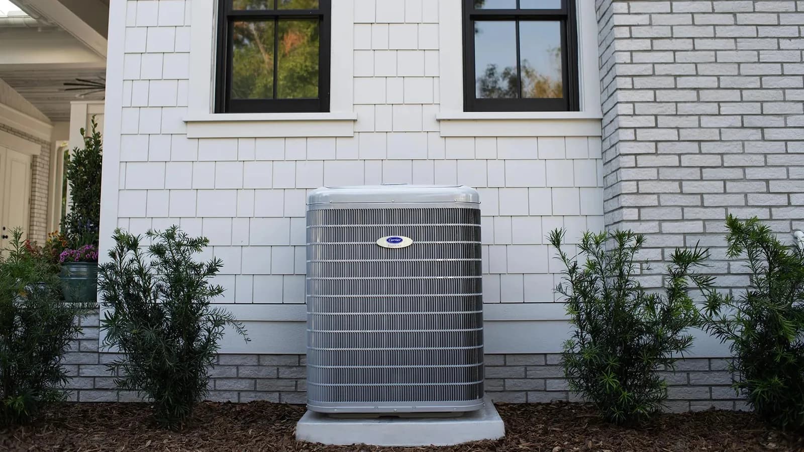 Carrier Infinity air conditioner installed outside a white home