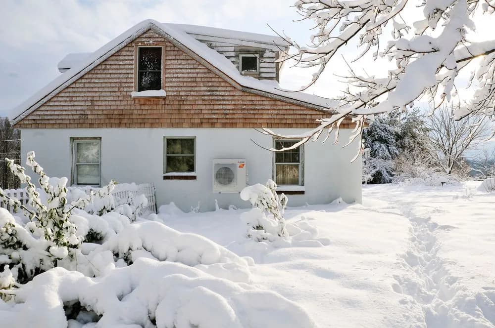 Mitsubishi Electric H2i heat pump outdoor unit mounted above deep snow