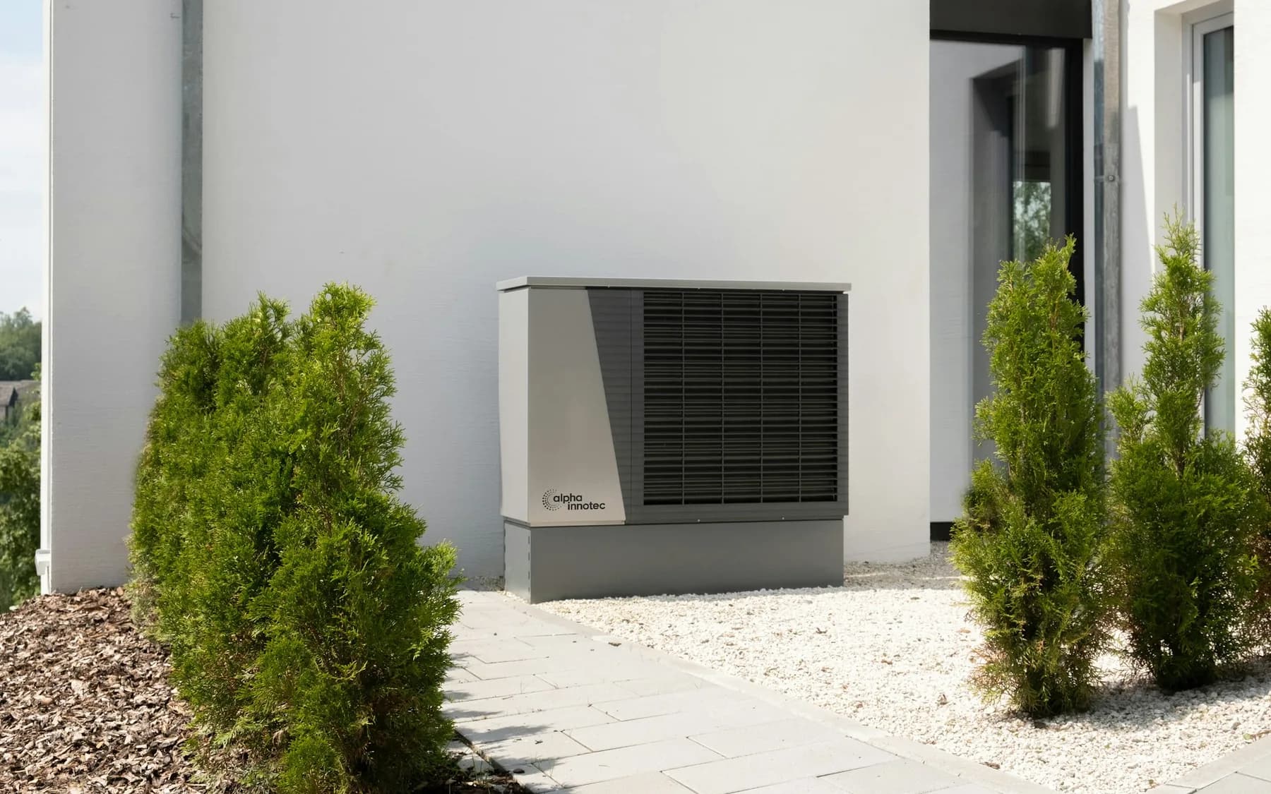 Outdoor air-conditioning unit installed beside a landscaped modern home