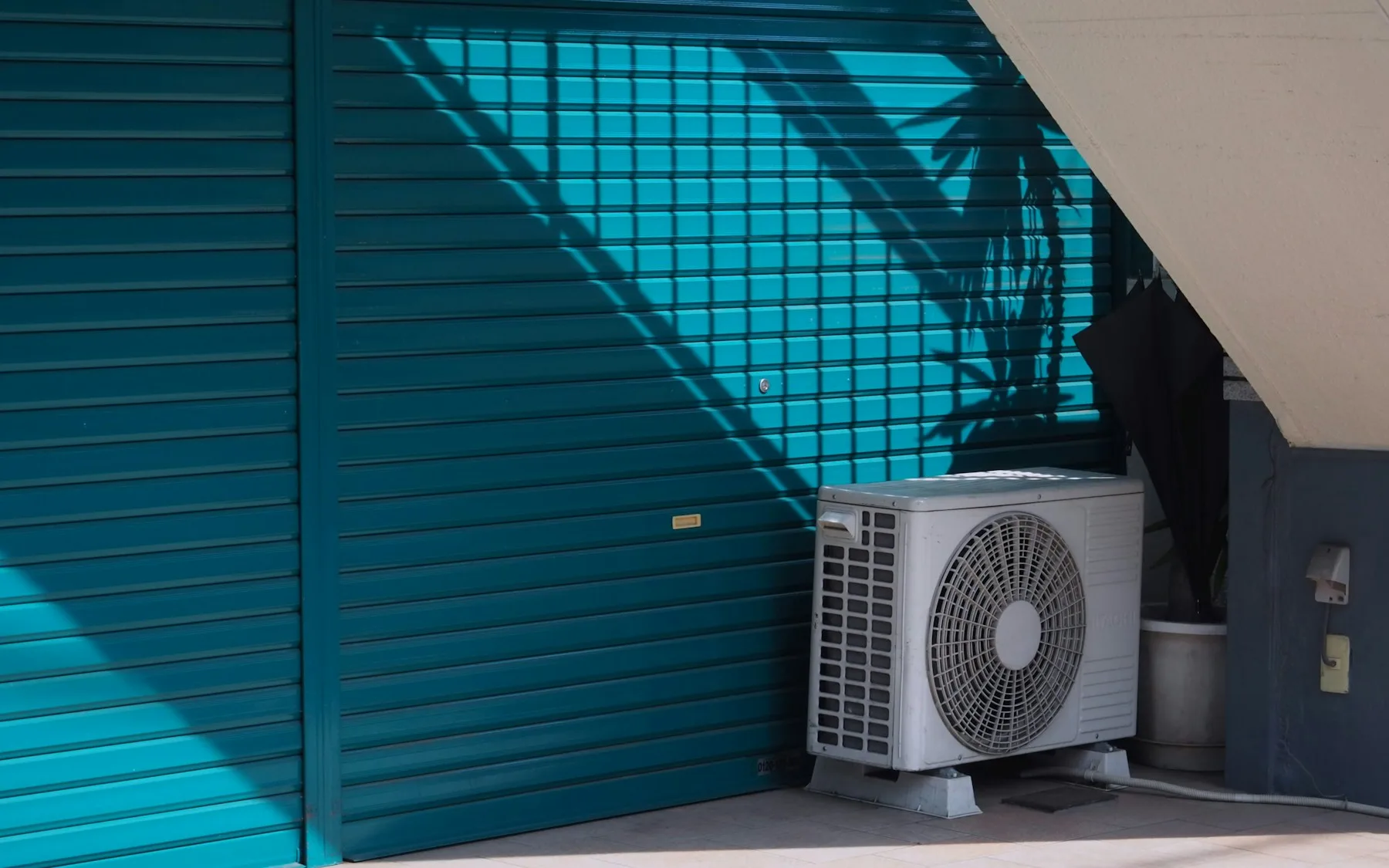 Outdoor air-conditioning unit mounted beside a weathered building wall