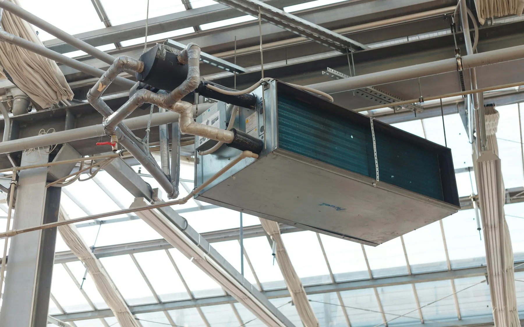 Large indoor HVAC air-handling unit suspended within a ceiling structure