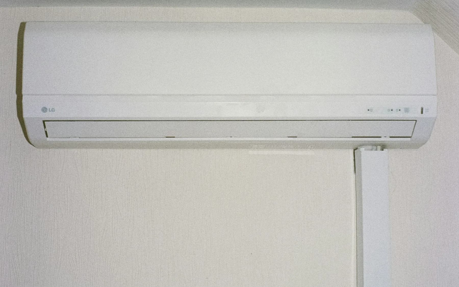 White wall-mounted ductless air conditioner installed above a room