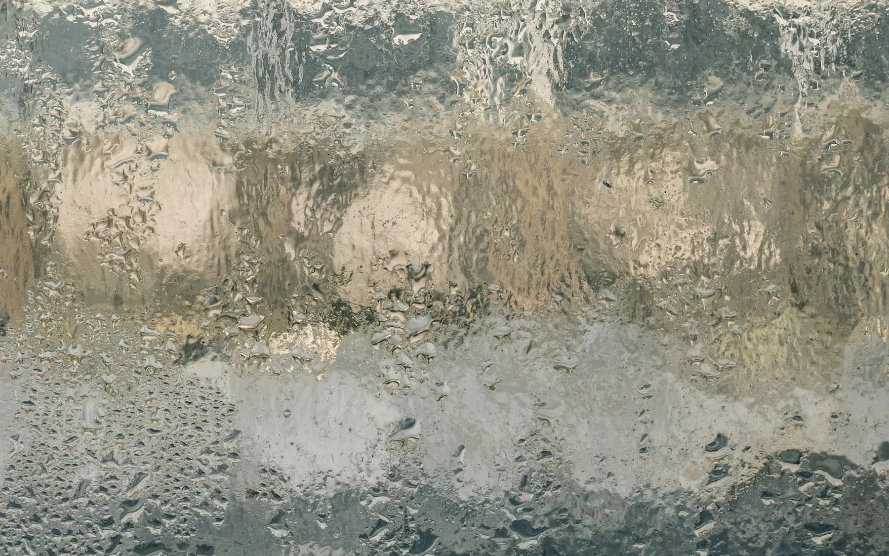 Condensation and water droplets covering a residential window